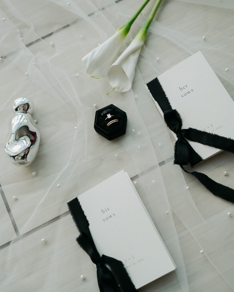 Modern and elegant wedding details of the bride's shoes, veil, vows, bouquet, and rings.