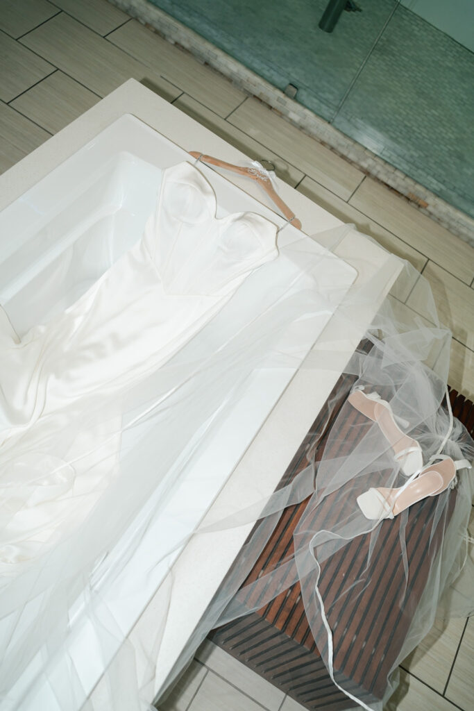 Modern and elegant wedding details of the bride's shoes, veil, vows, bouquet, and rings.