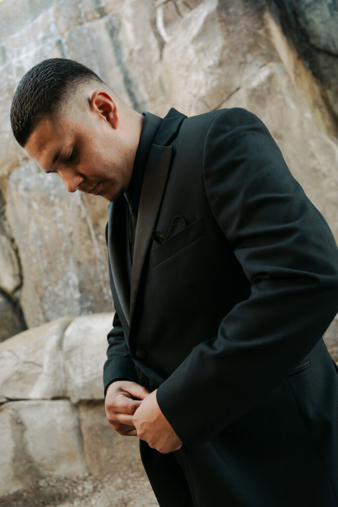 Groom getting ready in a modern all black tux for his wedding in Arizona.