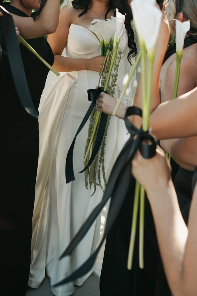 Minimal and modern white floral arrangement and simple black bows for the bridesmaids floral bouquets.
