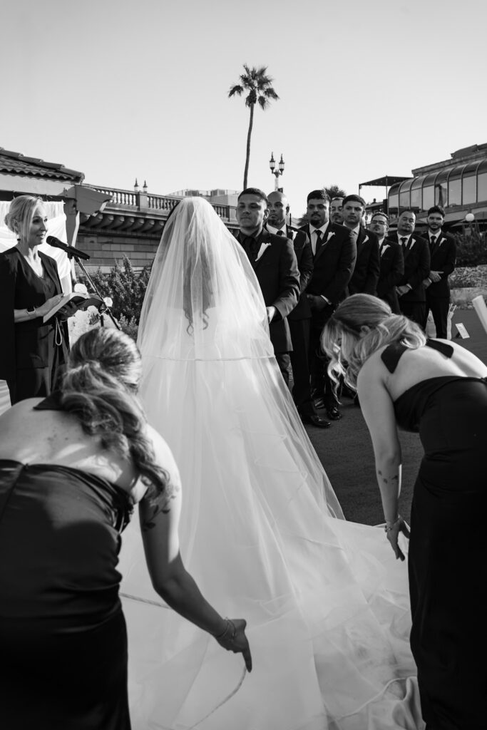 Bride and bridesmaids fixing the wedding dress during modern wedding ceremony in Arizona.