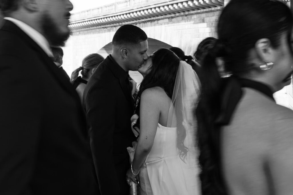 Bride and groom and their bridal party in all black attire in front of a the London Bridge during a modern, minimal wedding in Arizona
