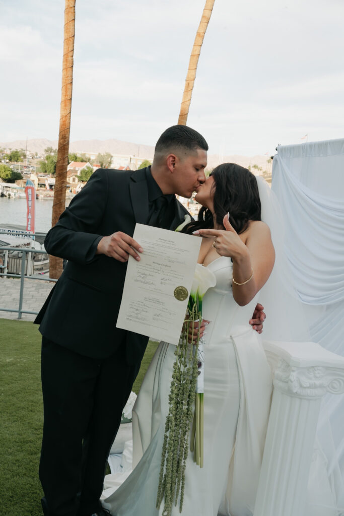Bride and groom sign their marriage license in front of a the London Bridge during a modern, minimal wedding in Arizona
