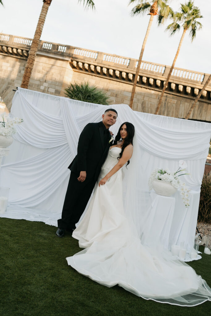 Bride and groom in front of a white draped ceremony backdrop during a modern, minimal wedding in Arizona