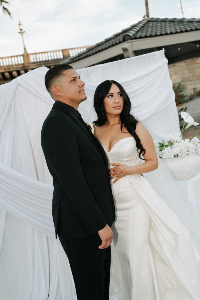Bride and groom in front of a white draped ceremony backdrop during a modern, minimal wedding in Arizona.
