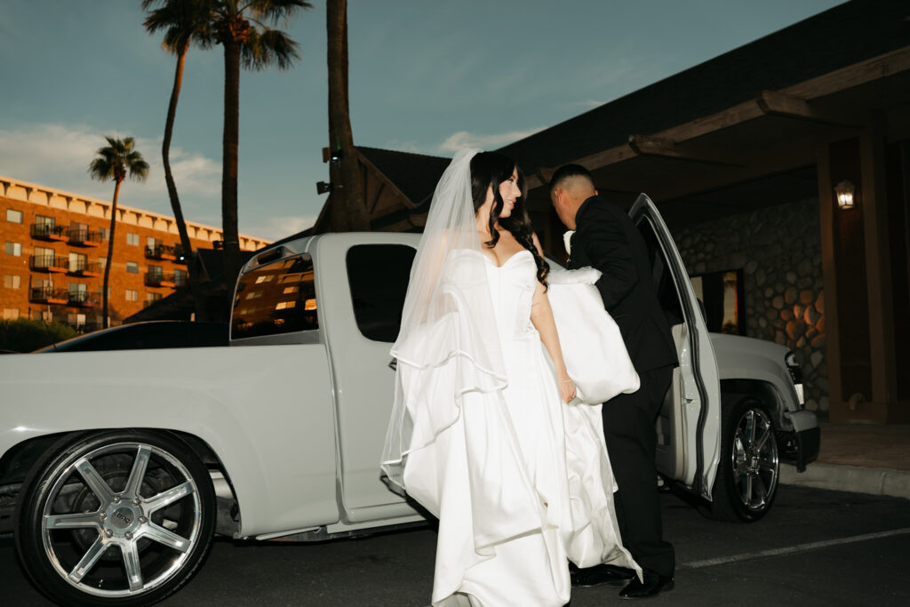 Bride and groom exiting a grey truck at dusk during their Arizona wedding, captured in a modern, documentary style.