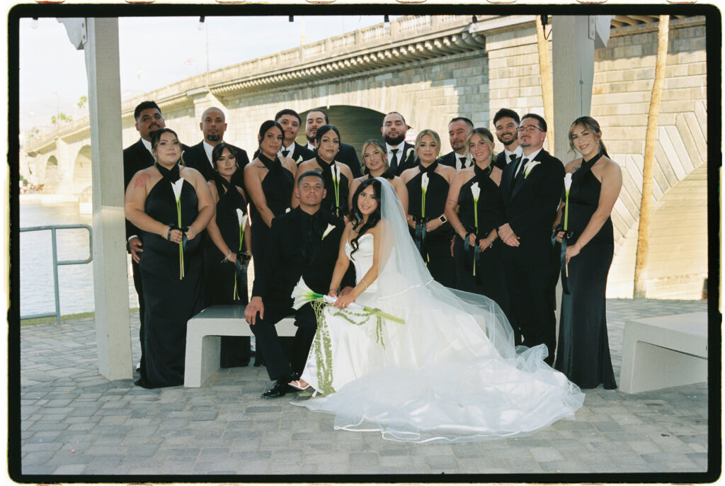 Bride and groom and their bridal party in all black attire in front of a the London Bridge during a modern, minimal wedding in Arizona